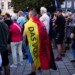 A man covering with a German national flag with the slogan "We are the people" listens to Bjoern Hoecke, top candidate of the far-right Alternative for Germany party, or AfD, during an election campaign rally of the party for upcoming state elections in Suhl, Germany, Tuesday, Aug. 13, 2024. (AP Photo/Markus Schreiber)