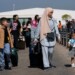 Turkish citizens carry their belongings, as they arrive at a gathering point to board a Turkish navy vessel to be evacuated to Turkey, in Beirut, Lebanon, Wednesday, Oct. 9, 2024. (AP Photo/Hussein Malla)