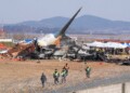 Firefighters and rescue team members work near the wreckage of a passenger plane at Muan International Airport in Muan, South Korea, Sunday, Dec. 29, 2024. (AP Photo/Ahn Young-joon)