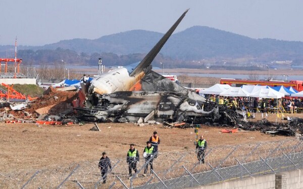 Firefighters and rescue team members work near the wreckage of a passenger plane at Muan International Airport in Muan, South Korea, Sunday, Dec. 29, 2024. (AP Photo/Ahn Young-joon)