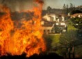 Flames rise as the Palisades Fire advances on homes in the Pacific Palisades neighborhood of Los Angeles, Tuesday, Jan. 7, 2025. (AP Photo/Ethan Swope)