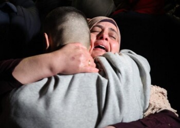 A Palestinian woman embraces her freed son upon his arrival among some 90 prisoners set free by Israel in the early hours of January 20, 2025, in the occupied West Bank town of Beitunia, on the outskirts of Ramallah. Crowds cheered, chanted and honked car horns as two buses carrying the prisoners arrived in Beitunia following their release as part of the Gaza ceasefire deal that began on January 19 and saw three Israeli hostages freed by Hamas in the Gaza Strip. (Photo by Zain JAAFAR / AFP)