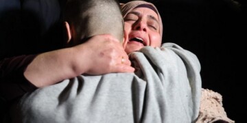 A Palestinian woman embraces her freed son upon his arrival among some 90 prisoners set free by Israel in the early hours of January 20, 2025, in the occupied West Bank town of Beitunia, on the outskirts of Ramallah. Crowds cheered, chanted and honked car horns as two buses carrying the prisoners arrived in Beitunia following their release as part of the Gaza ceasefire deal that began on January 19 and saw three Israeli hostages freed by Hamas in the Gaza Strip. (Photo by Zain JAAFAR / AFP)