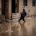 A woman walks through the mud as she tries to arrive at her home on a still flooded street in Masanasa, Valencia, Spain, Thursday, Nov. 7, 2024. (AP Photo/Emilio Morenatti)